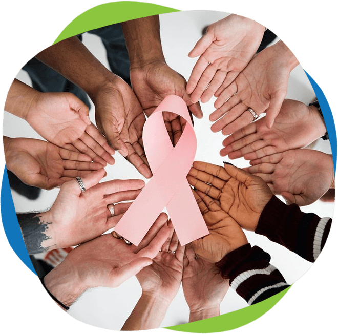 A group of people holding hands around a pink ribbon.